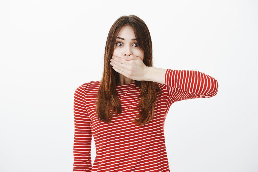 Mulher tapando a boca com a mão